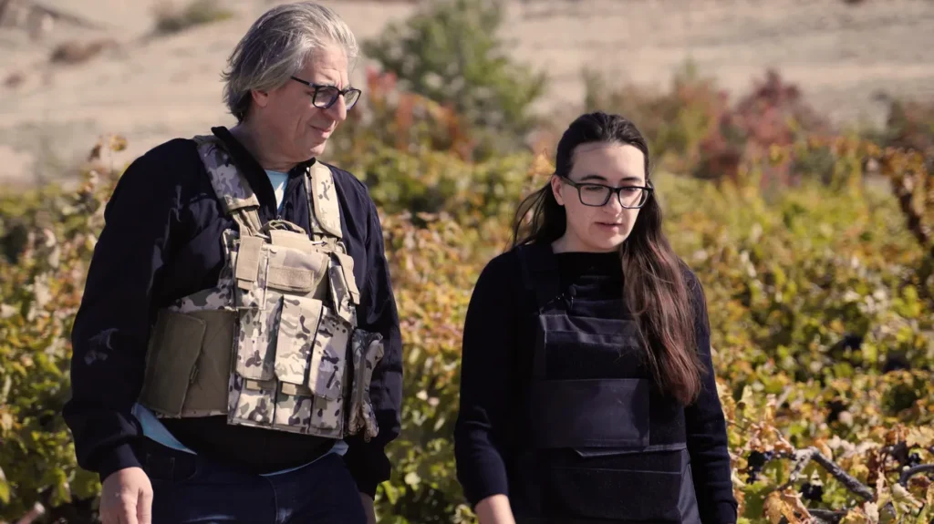 Vahe Keushguerian (izquierda) y su hija, Aimee, usan chalecos antibalas mientras cosechan uvas en la frontera de Armenia y Azerbaiyán.